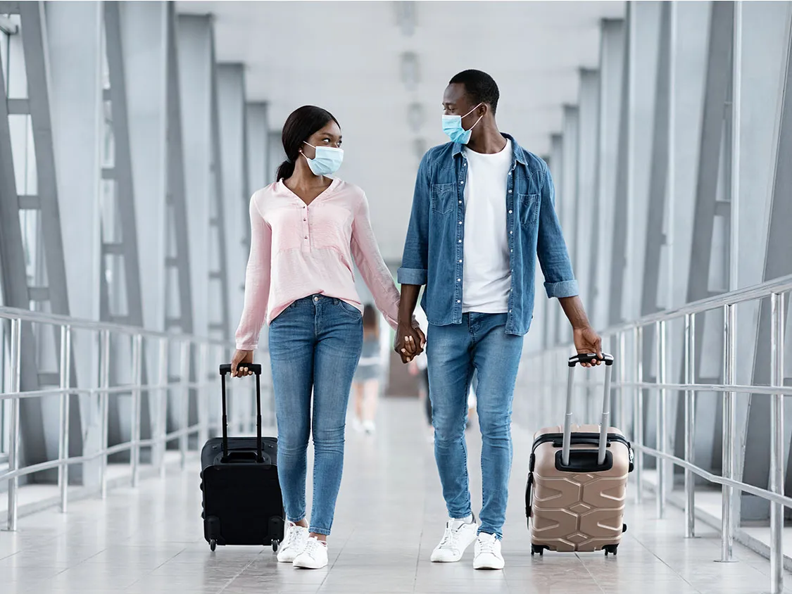 people walking through Airport with face masks